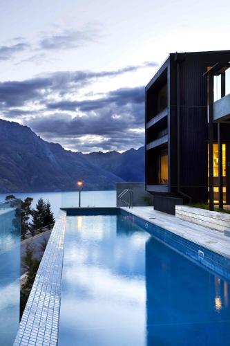 a house with a swimming pool next to a body of water at Aspen Grove by Sotheby's Luxury Rental Homes in Queenstown