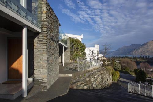 a stone house with a view of the mountains at Lago Infinito by Sotheby's Luxury Rental Homes in Queenstown