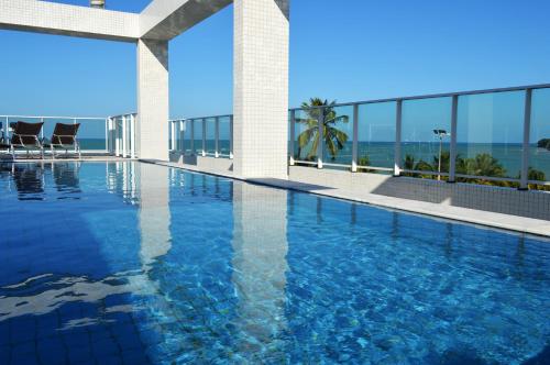 uma piscina com vista para o oceano em Val Atlantic Hotel em João Pessoa