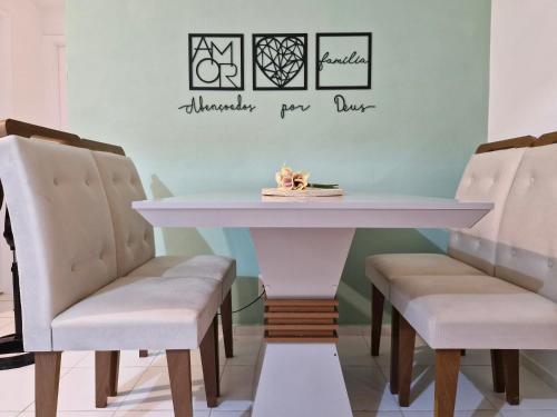 a dining room table with two chairs and a white table at Apto Araçagy Ilha de São Luis in São-José-do-Ribamar