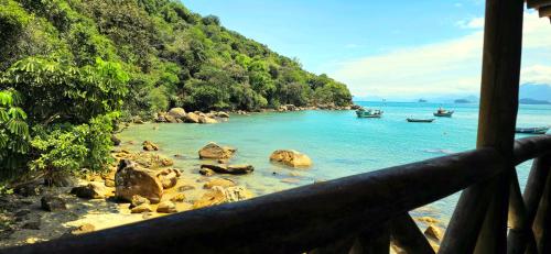 a view of a beach with boats in the water at Pousada Sobre As Ondas de Picinguaba in Picinguaba