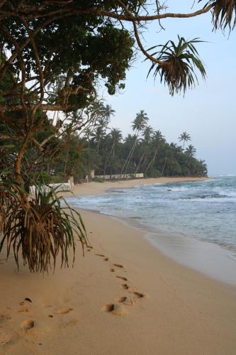 a pair of footprints in the sand on a beach at The Villa Sea Breeze in Talpe
