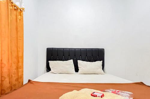 a bed with a black headboard in a room at Good Sleep 4 RedPartner in Samarinda