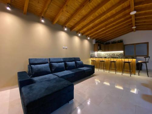 a living room with a blue couch and a kitchen at Fraternity Room - a solo una cuadra del parque in Carmen de Viboral