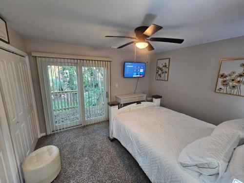 una camera da letto con due letti e un ventilatore a soffitto di The Cozy Townhome a Tallahassee