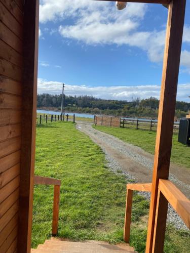 a view from the window of a cabin with a dirt road at El Encanto de Antilhue in Valdivia