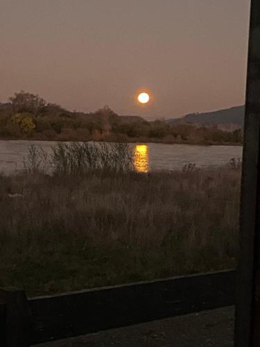 a sunset from a train window looking out at a river at El Encanto de Antilhue in Valdivia