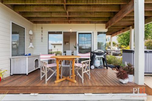 a patio with a table and chairs on a deck at Tranquil Holiday Retreat Rhyll in Rhyll