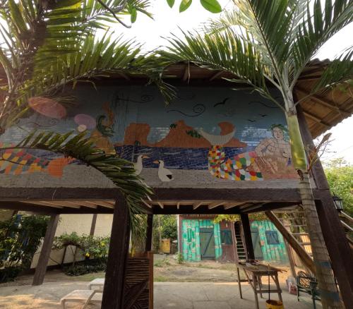 a mural on the side of a building with a palm tree at La Perla Hostel and Cabins in Las Tunas