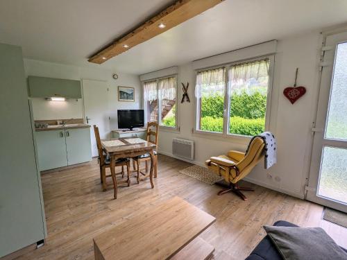 un salon avec une table et des chaises et une cuisine dans l'établissement Gîte montagne La Bresse, balcon, Wi-Fi, parking proche ski - FR-1-589-699, à La Bresse