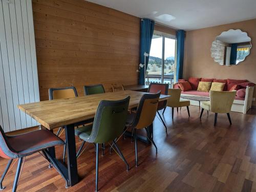une salle à manger avec une table, des chaises et un canapé dans l'établissement Appartement 8 pers, 3 pièces, sud-ouest, parking et animaux admis - FR-1-504-690, à Superdevoluy