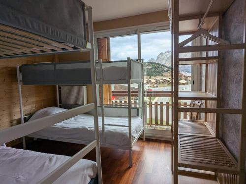 une chambre avec deux lits superposés et une fenêtre dans l'établissement Appartement 8 pers, 3 pièces, sud-ouest, parking et animaux admis - FR-1-504-690, à Superdevoluy