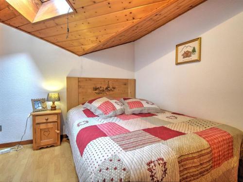 une chambre avec un lit et un plafond en bois dans l'établissement Morzine : Charmant 2 pièces avec mezzanine, 4-5 pers., proche télécabine, parking inclus - FR-1-524-132, à Morzine