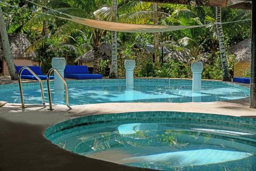 a large swimming pool with blue chairs in a resort at Likuri Island Resort Fiji in Natadola