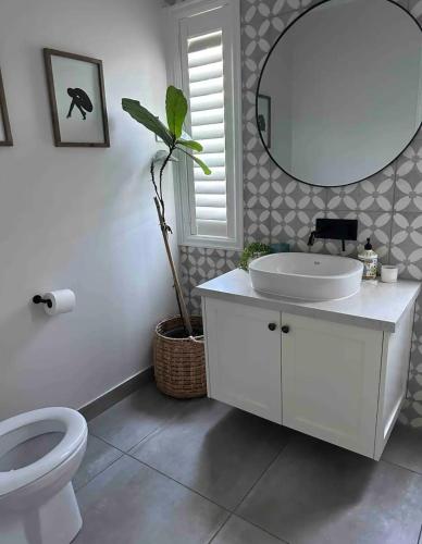 a bathroom with a toilet and a sink and a mirror at Lakehouse in Yarrawonga