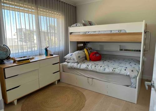 a small bedroom with a bunk bed and a dresser at Lakehouse in Yarrawonga
