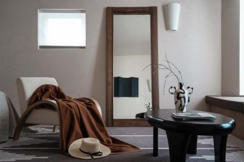 a living room with a table and a mirror at Miyue Shenzhen Blue and White Holy Island Cliff Pool Hotel in Shenzhen