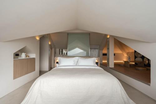 a bedroom with a large white bed in a attic at Miyue Shenzhen Blue and White Holy Island Cliff Pool Hotel in Shenzhen