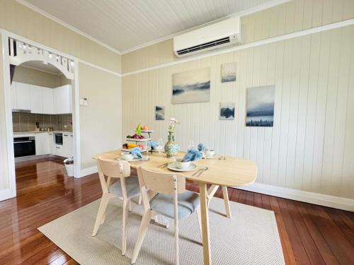 a dining room with a wooden table and chairs at Stylish & Bright 3-BDRS Family in Holland Park West in Brisbane