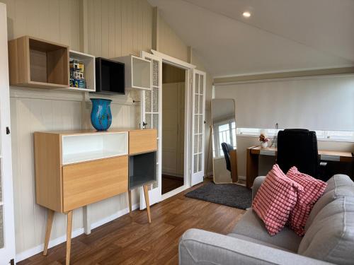 a living room with a couch and a desk at Stylish & Bright 3-BDRS Family in Holland Park West in Brisbane