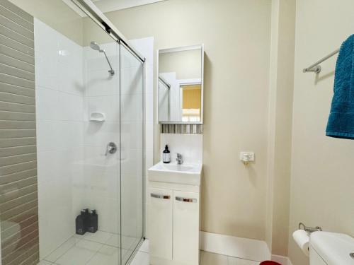 a bathroom with a glass shower and a sink at Stylish & Bright 3-BDRS Family in Holland Park West in Brisbane