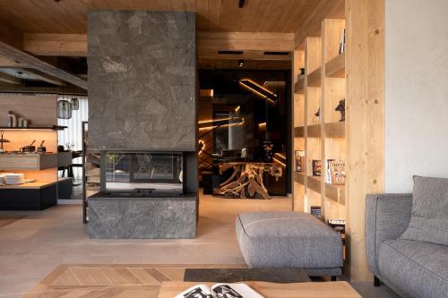 a living room with a fireplace and a chair at Villa La Roca Garden and Spa in Kościelisko