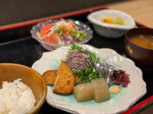 a plate of food on a table with rice at APA Hotel Kagoshima Chuoekimae Nishiguchi in Kagoshima