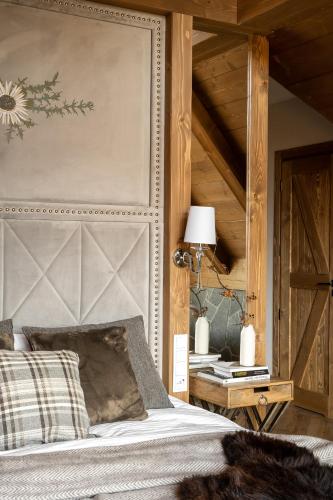 a bedroom with a bed with a large headboard at Villa La Roca Garden and Spa in Kościelisko