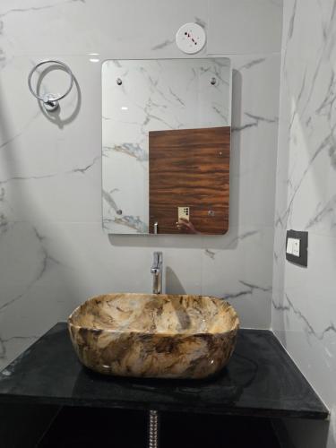 a bathroom with a large stone sink and a mirror at Lakshmi Villa Hampi in Hampi
