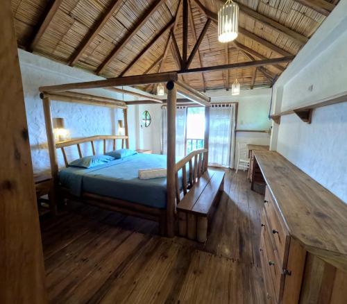 a bedroom with a bed and a wooden floor at La Perla Hostel and Cabins in Las Tunas
