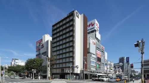 a tall building on the corner of a city street at AB Hotel Sakaihigashi in Sakai