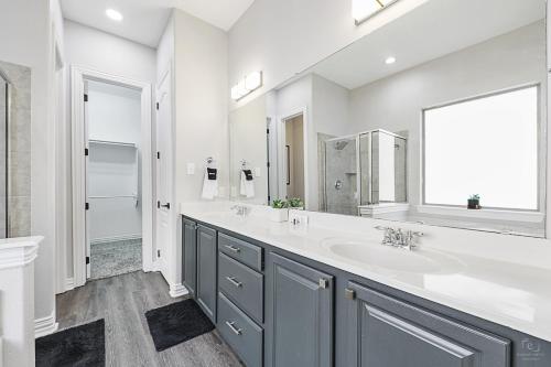 a bathroom with two sinks and a large mirror at Cozy 5BR Estate Lewisville - Office, Game Room in Lewisville