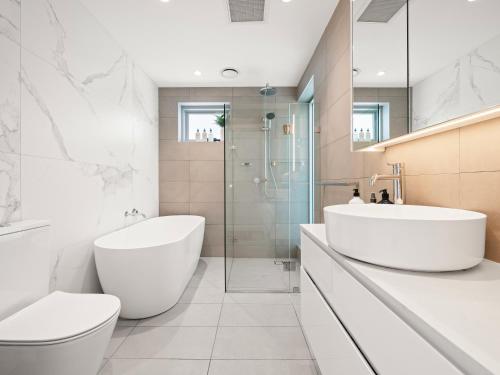 Un baño con dos lavabos, un inodoro y una ducha. en The Nancy Bondi, en Sídney