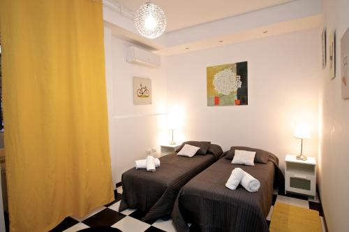 a bedroom with two beds and a yellow curtain at Flaminio Butterfly House in Rome