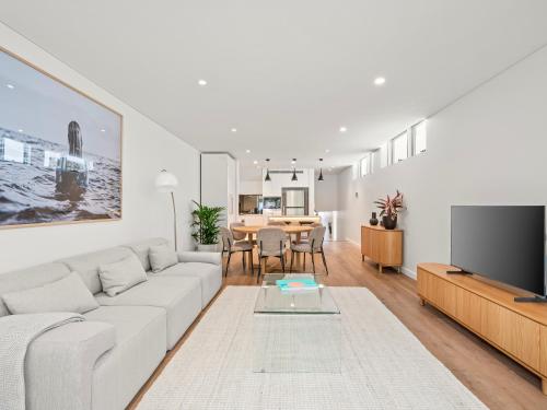a living room with a white couch and a tv at The Nancy Bondi in Sydney