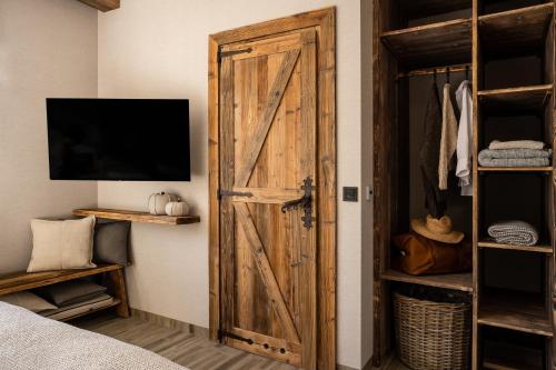 a sliding barn door in a bedroom with a tv at Villa La Roca Garden and Spa in Kościelisko