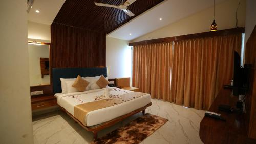 a bedroom with a large bed and a television at Nisarga Lake Resort Tapola in Satara