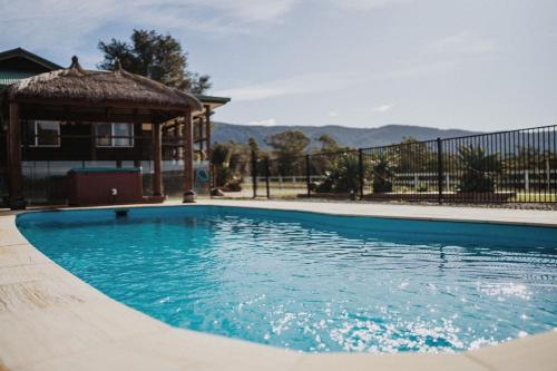 una piscina con cenador junto a una casa en Cooranbong Rural Farm Creekside, en Cooranbong