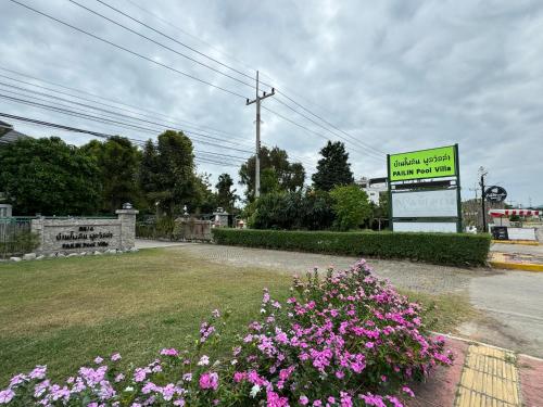 a sign for a hotel with pink flowers in a yard at Pailin Pool Villa,HuaHin in Hua Hin