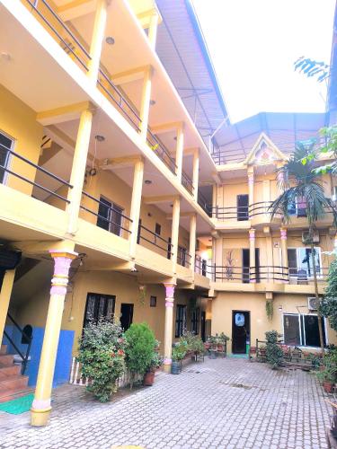 a large building with balconies and a courtyard at Nikunj Safari Guest House Sauraha- A place where you can book jungle wildlife Safari in Sauraha