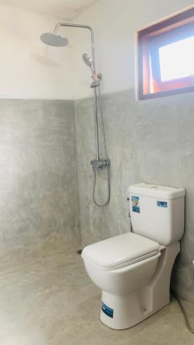 a bathroom with a toilet and a shower at The Retreat Hotel in Hikkaduwa