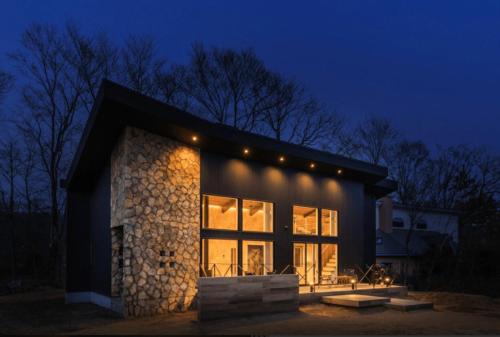 a house with lights on the side of it at night at Tabinoteitaku Miyagi Zao in Zao
