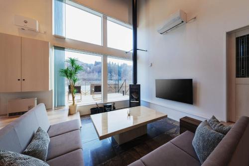 a living room with a couch and a table at Tabinoteitaku Miyagi Zao in Zao