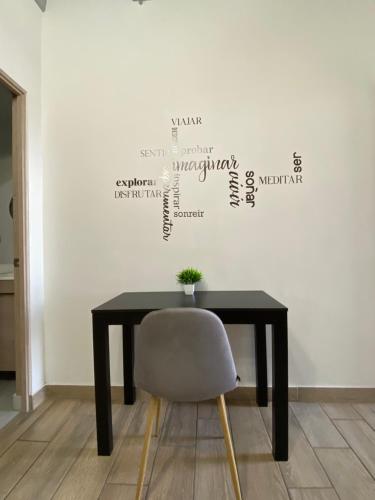 a table and a chair in a room with a wall at Lux 2 bedroom apartment, swimming pool, gym and free parking spot in Macro Plaza area in Monterrey
