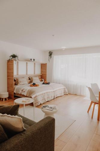 a bedroom with a large bed and a couch at Superb Modern Studio Leukerbad in Leukerbad