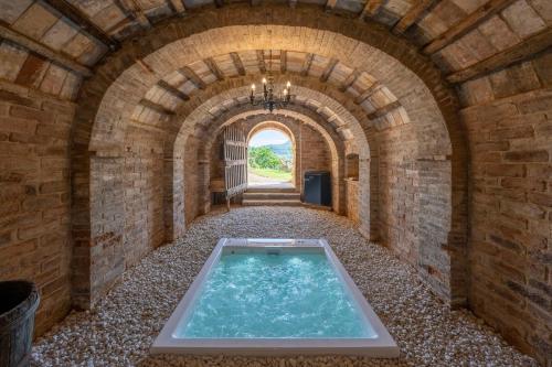 a hot tub in a brick tunnel with a window at Stelle di Monte in Montepulciano