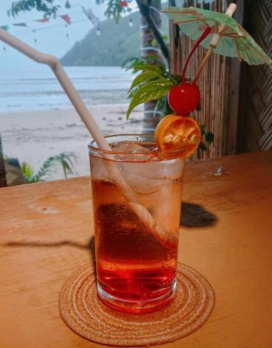 a drink sitting on a table with a cherry on it at Balai Ko Beach & Cottages in El Nido
