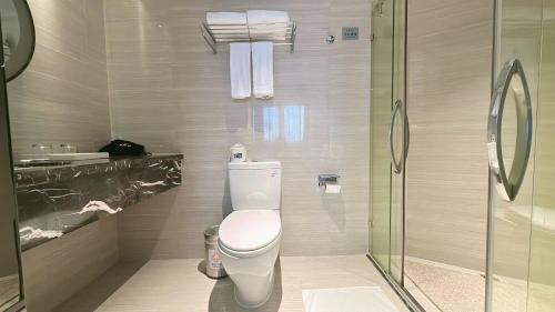 a bathroom with a toilet and a glass shower at Holiday Inn Express Xiamen Lushan -Shopping Center by IHG in Xiamen