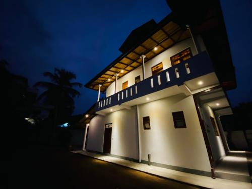 a white building at night with a dark sky at Coco Bay Villa in Galle