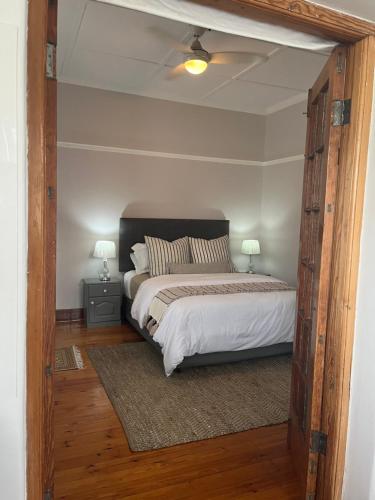 a bedroom with a bed with a large wooden door at Casa Sí Apartment in Gqeberha